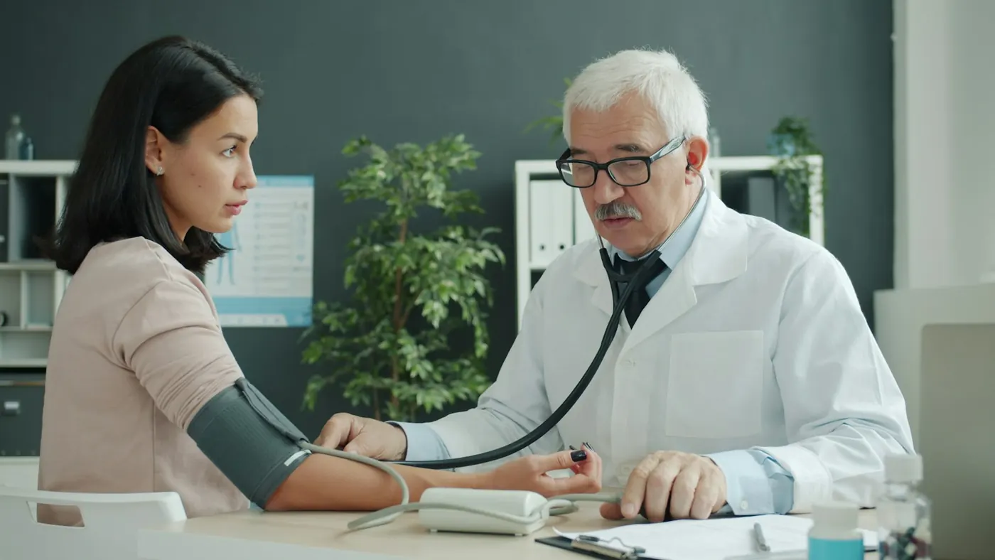 A doctor checking a patient's blood pressure