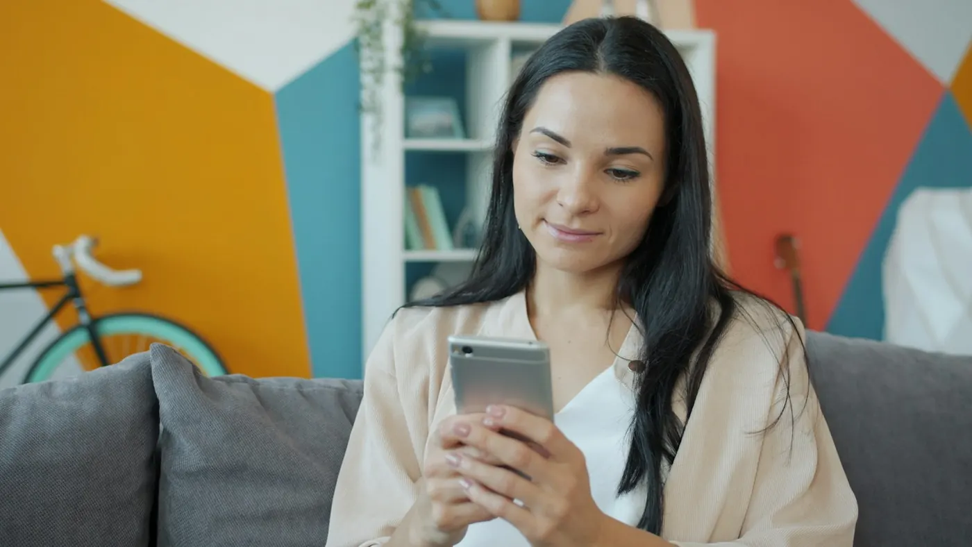 A woman reading her phone at home