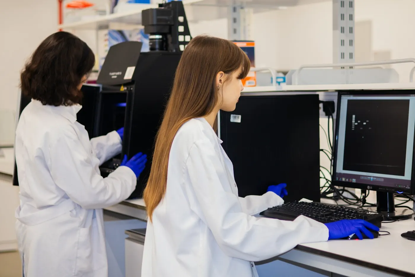 Two researchers working at computers in a lab